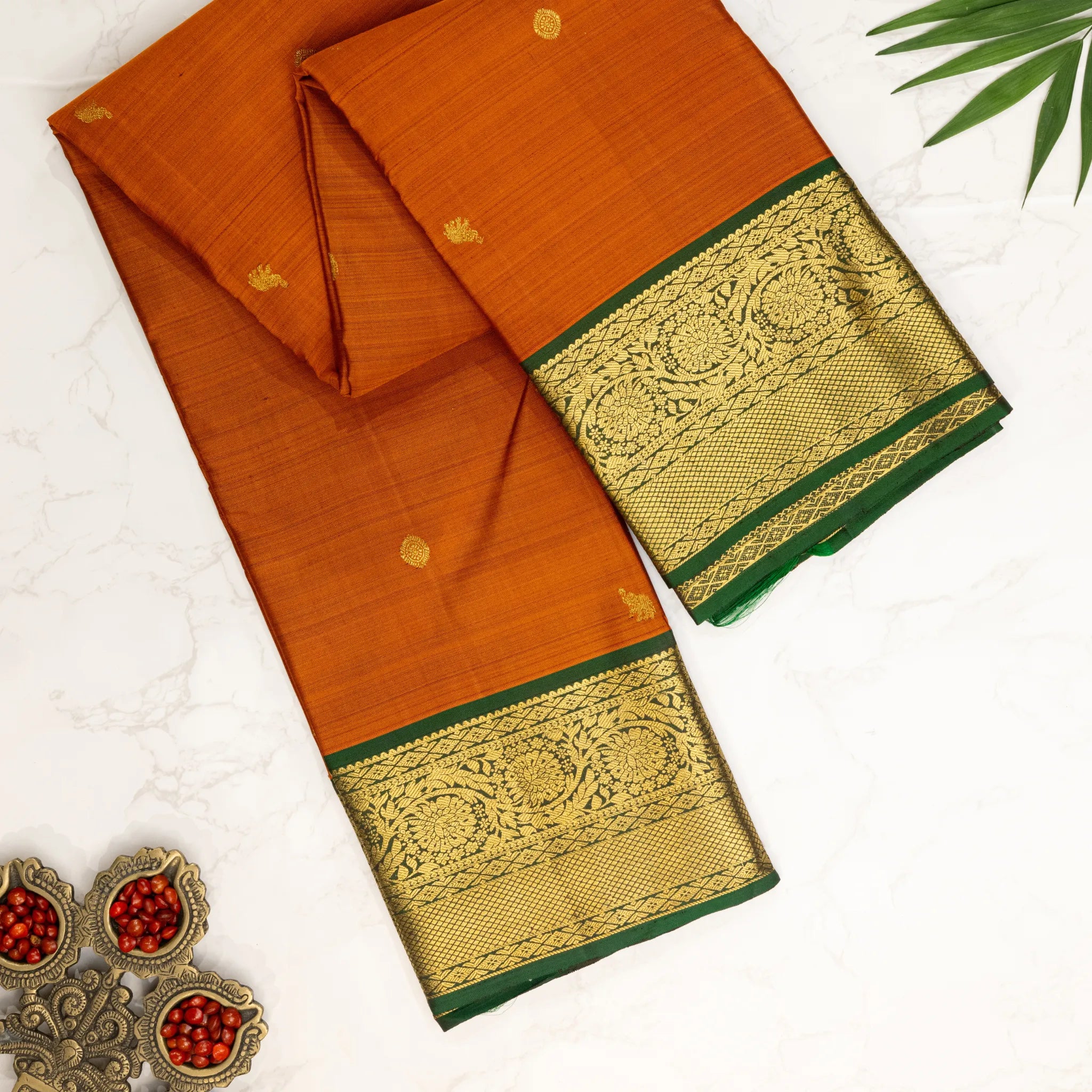 Mustard Orange Kanchipuram Silk Saree – Gold Zari Buttas with Green Floral Border