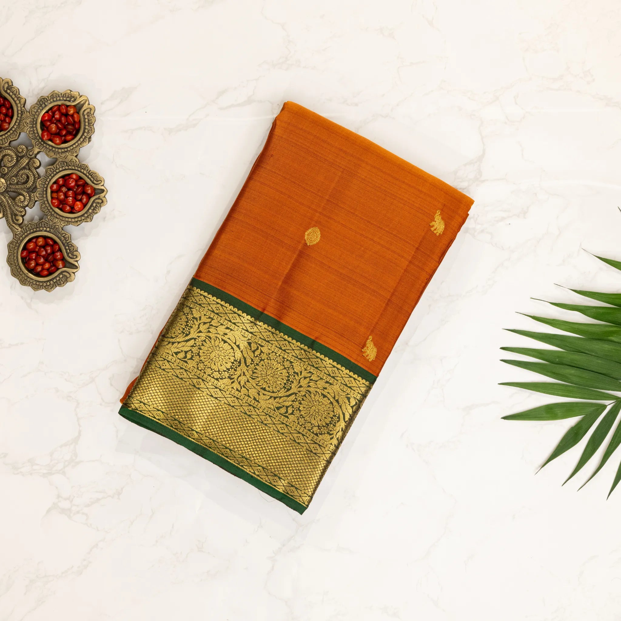 Mustard Orange Kanchipuram Silk Saree – Gold Zari Buttas with Green Floral Border